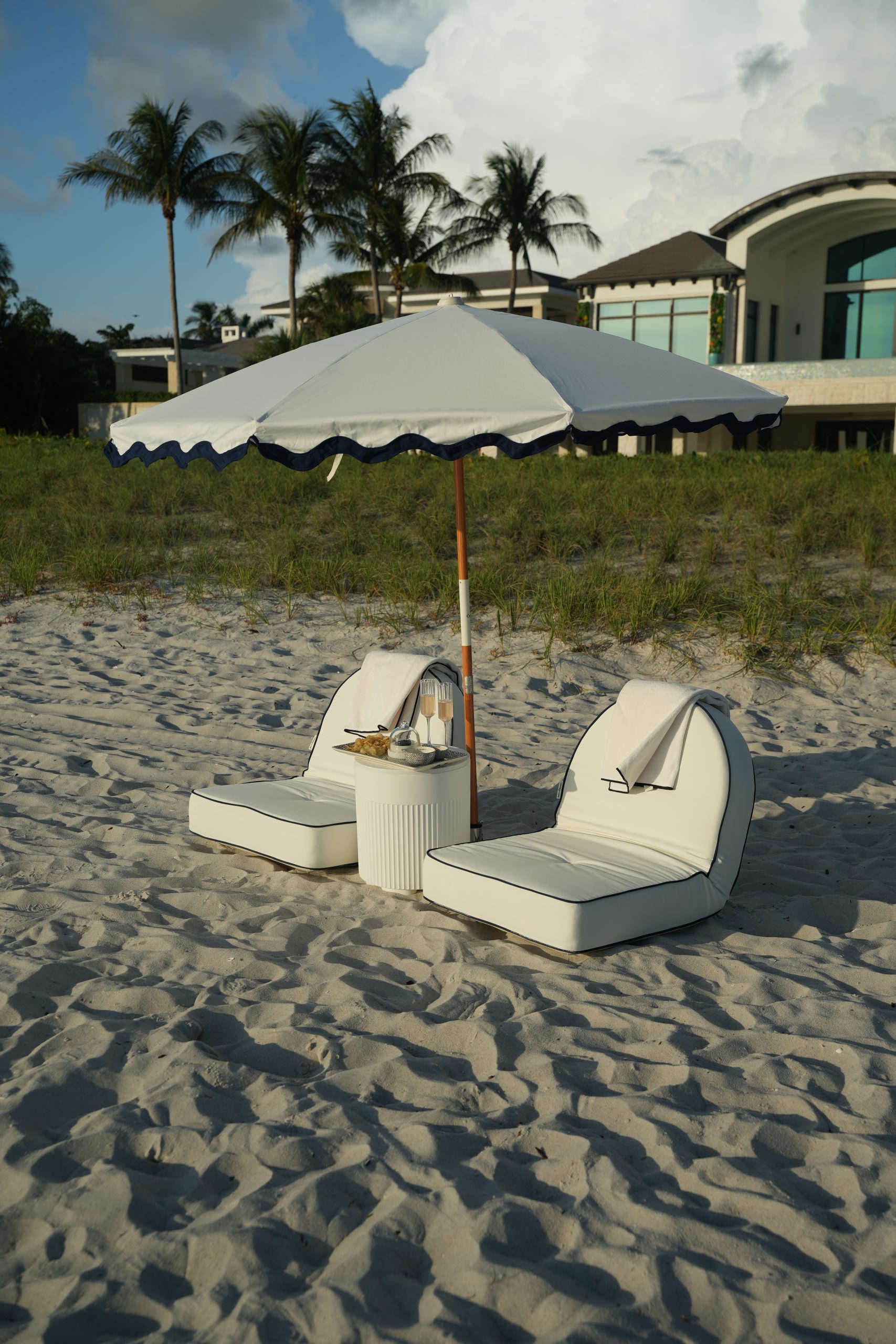 Striped fringe umbrellas and beach chairs arranged for a group on the Naples sand